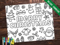 merry christmas coloring page with markers and pencils on wooden table next to wood background