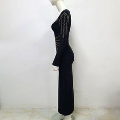 a mannequin wearing a black dress with gold beadings on the back