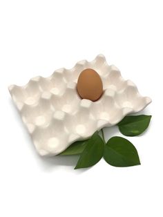 an egg is sitting on top of a white plate with green leafy leaves around it