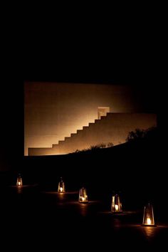 several lit candles sitting in front of a staircase