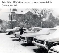 a person standing in the snow next to parked cars