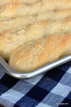 a baking pan filled with bread on top of a blue and white checkered table cloth