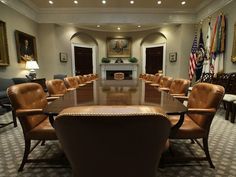 an empty conference room with chairs and tables in front of the fire place is shown