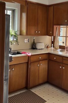 a kitchen with wooden cabinets and white counter tops