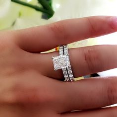 a woman's hand with a ring on it that has two diamonds in the middle