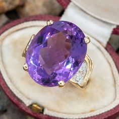 This amethyst cocktail ring is centered with one (1) oval mixed cut natural amethyst set into a four-prong setting. The shoulders of the ring are each accented with five (5), bead set, round brilliant cut diamonds. The ring measures 20.0mm at the top, rises 12.1mm above the finger, tapering to 3.3mm wide and 0.9mm thick at the base of the shank. The ring is currently a size 5. Luxury Purple Oval Gemstones, Oval Amethyst Ring In Luxury Style, Luxury Oval Amethyst Ring With Prong Setting, Oval Amethyst Gemstones For Formal Occasions, Formal Oval Amethyst Gemstones, Oval Amethyst Ring For Formal Occasions, Oval Amethyst Ring With Center Stone For Formal Occasions, Formal Lavender Amethyst Ring With Oval Shape, Formal Lavender Oval Amethyst Ring