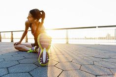 a woman is sitting on the ground with her headphones in her ears and listening to music