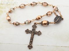 "One decade Catholic rosary beads with Miraculous medal and Eucharistic crucifix. Single decade pocket rosary is made in unbreakable wire wrapped technique with 8mm and 12mm crystal half metallic copper Czech glass beads and antique copper medal and crucifix. Our Czech glass beads are sourced directly from high quality Czech glass factory. All of the materials used in making rosaries are hand picked and undergo utmost quality check. Rosary's length is about 8\" (21 cm) Crucifix: 1.1\"x 1.8\" (2. Vintage Rosary Bracelet With Round Beads As Gift, Bronze Rosary As Gift, Bronze Rosary With Round Beads As Gift, Vintage Adjustable Rosary With Round Beads, Vintage Adjustable Rosary, Amber Rosary With 8mm Beads, Spiritual Style, Bohemian Hand-strung Healing Rosary, Antique Crucifix Rosary Gift, Rosary Beads Catholic