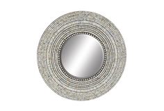 a round mirror with beading around it on a white wall mounted shelf above the mirror