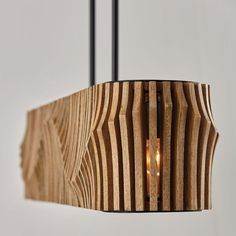 a wooden light hanging from a ceiling fixture with a candle in it's center