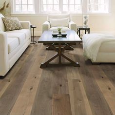 a living room with wood floors and white furniture