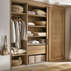 an open closet with clothes and baskets in it