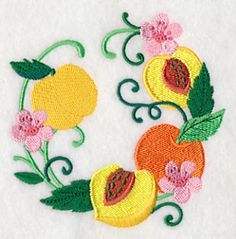 an embroidered applique with fruit and flowers on white fabric, in the shape of a letter o