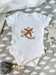 100% cotton baby vest personalised with embroidery. Beautiful quality and super soft cotton baby bodysuit, baby grow or t-shirt. Please see the photos to choose colour of the thread.(you can add all the details with name in personalisation box) 🧵Personalisation: High Quality Embroidery. Personalisation takes 1-3 working days and we use only certified embroidery threads that are suitable for babies and children. 🧽CARE INSTRUCTIONS * This garment is delicately finished by hand so please wash inside out and on a cool wash. 📦Delivery: We can post items directly to the recipient with free gift message that will be printed on textured cardstock with lovely style font. Gift wrapping is available as well with a small extra charge. If your item is marked as a gift you will receive a photo of the White Cotton Top For Travel, First Time Flyer, Embroidery Threads, Baby Arrival, Personalized Gifts For Kids, Baby Grow, Baby Vest, Gender Neutral Baby Clothes, Embroidered Clothes