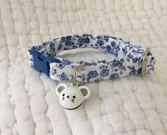 a blue and white dog collar with a cute monkey charm on it's side