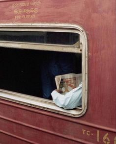 a person is looking out the window of a train car with paper on it's side