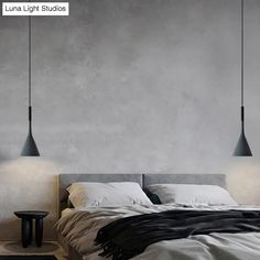 a bed with two lamps hanging over it