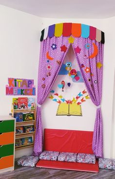 a child's bedroom decorated in pink and purple with colorful curtains on the bed