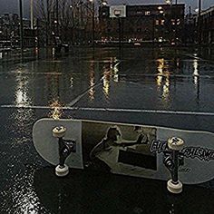 a skateboard sitting on top of a wet parking lot