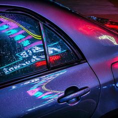 a car that is sitting in the street with neon lights on it's windows