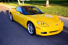 a yellow sports car is parked on the street