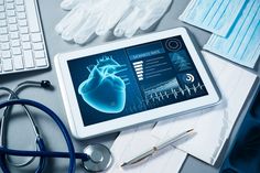 a tablet with medical equipment on top of it next to a keyboard, mouse and pen