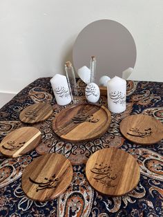 four wooden coasters with arabic writing on them sitting on a blue table cloth in front of a mirror