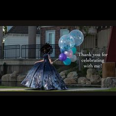 a woman in a blue dress is holding balloons with the words thank you for celebrating with me