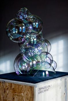 a stack of glass balls sitting on top of a wooden box