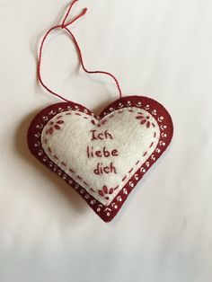 a red and white heart ornament with words on it that says, tech libe dich