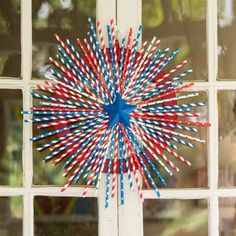 red, white and blue straws are arranged in the shape of a star on a window sill