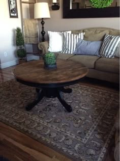 a living room with a couch, table and mirror in the corner on the wall