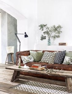 a living room filled with lots of furniture and pillows on top of a wooden table