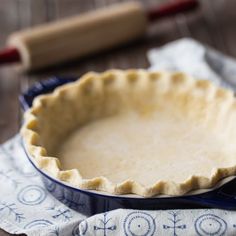 an uncooked pie crust on top of a blue dish