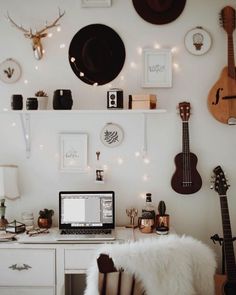 a laptop computer sitting on top of a desk next to a wall with pictures and lights