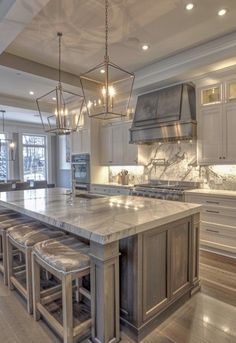 a large kitchen with marble counter tops and an island in front of the stove top