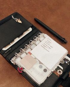 an open notebook sitting on top of a table next to a pen and notepad