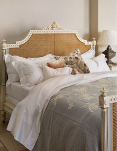 a bed with white linens and pillows on it