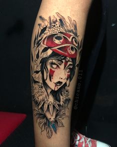 a woman's leg with a red hat and flowers on her head is covered in black ink