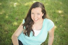 a woman is posing for a photo in the grass