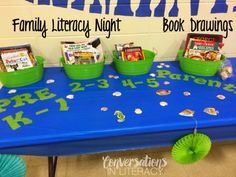 a blue table topped with green buckets filled with books