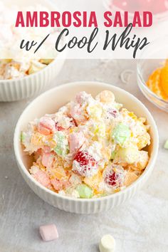 two bowls filled with fruit salad next to marshmallows