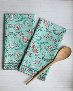 two teal floral napkins with wooden spoon