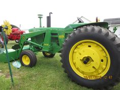 an old tractor is parked in the grass