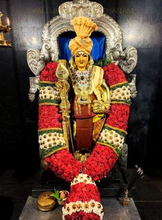 the statue is decorated with red flowers and gold