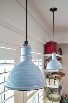 two light fixtures hanging from the ceiling in a kitchen