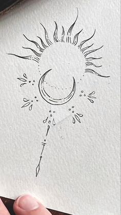 someone is drawing a sun and moon on paper