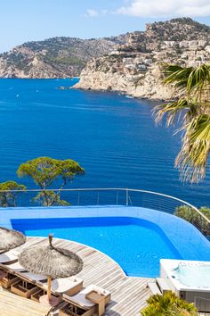 an outdoor swimming pool next to the ocean