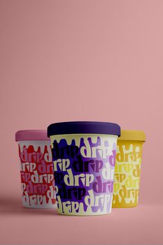 three ice cream containers sitting on top of each other in front of a pink background