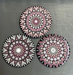 three pink and white plates sitting on top of a metal tablecloth covered countertop